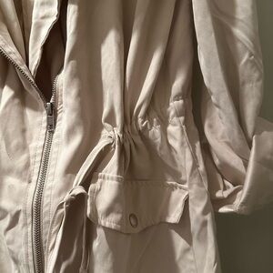 Rain coat beige ties tight in the middle to cinch off waist.